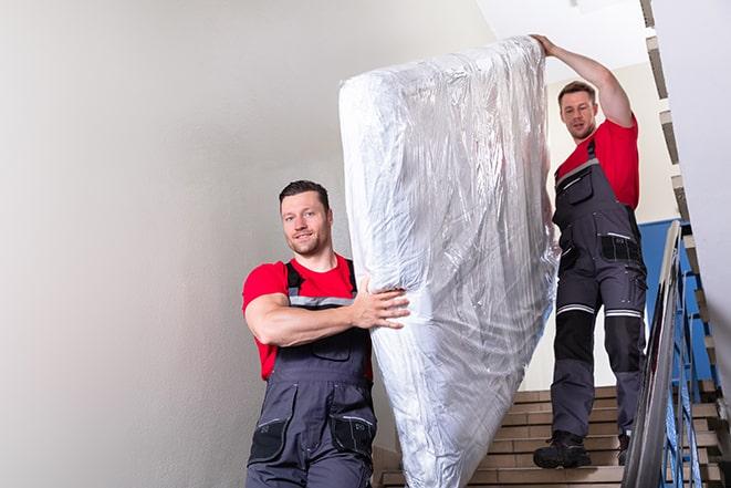 heavy lifting as a box spring is carried out of a house in Hanover